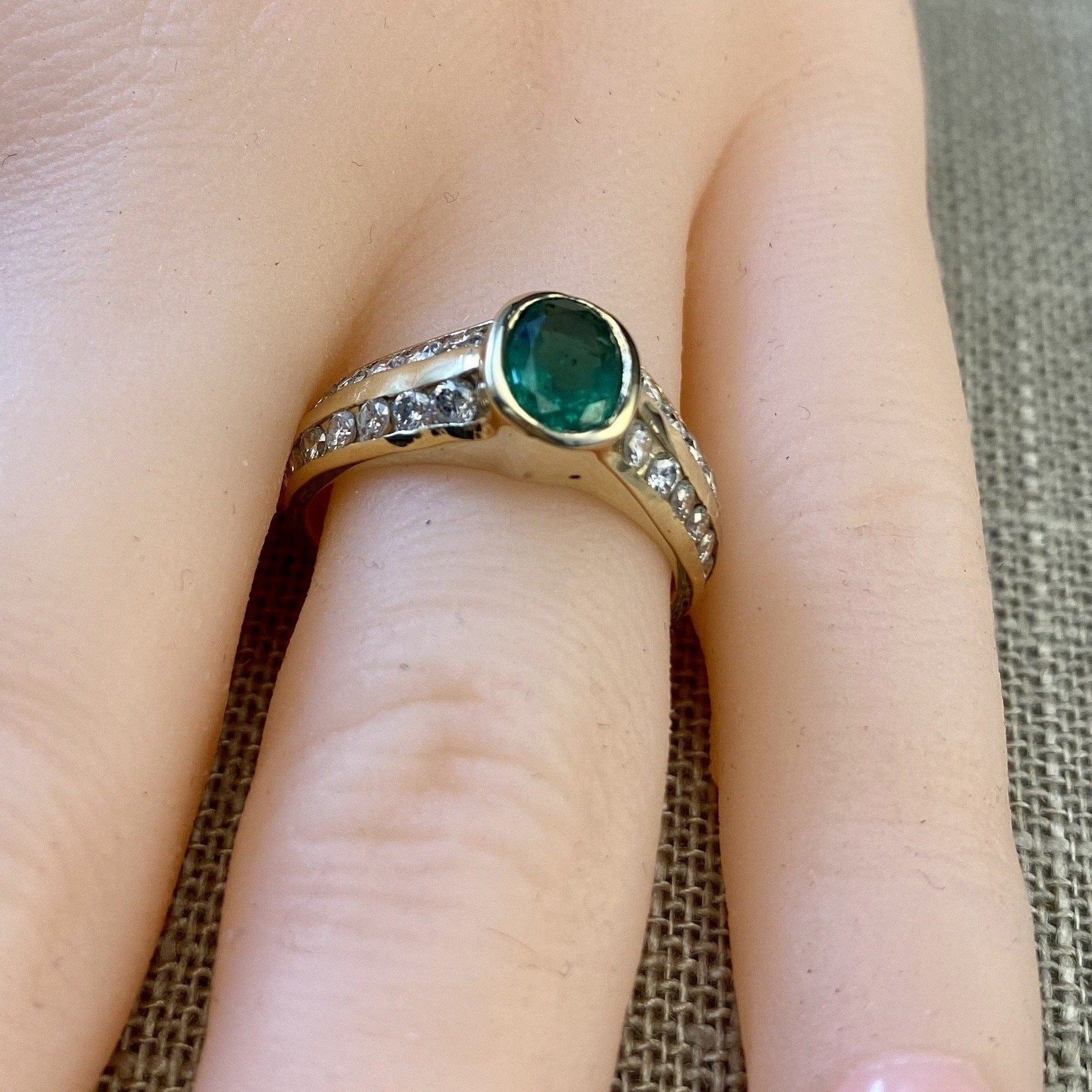 FJL Jewelry Gemstone Ring Exquisite oval-cut emerald weighing 0.88 carats surrounded by channel-set brilliant diamonds totaling 0.65 carats, low bezel setting
